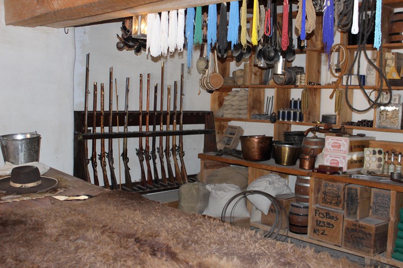 Traderoom A wooden counter is in the foreground of a trade room, with sales items on display in the background