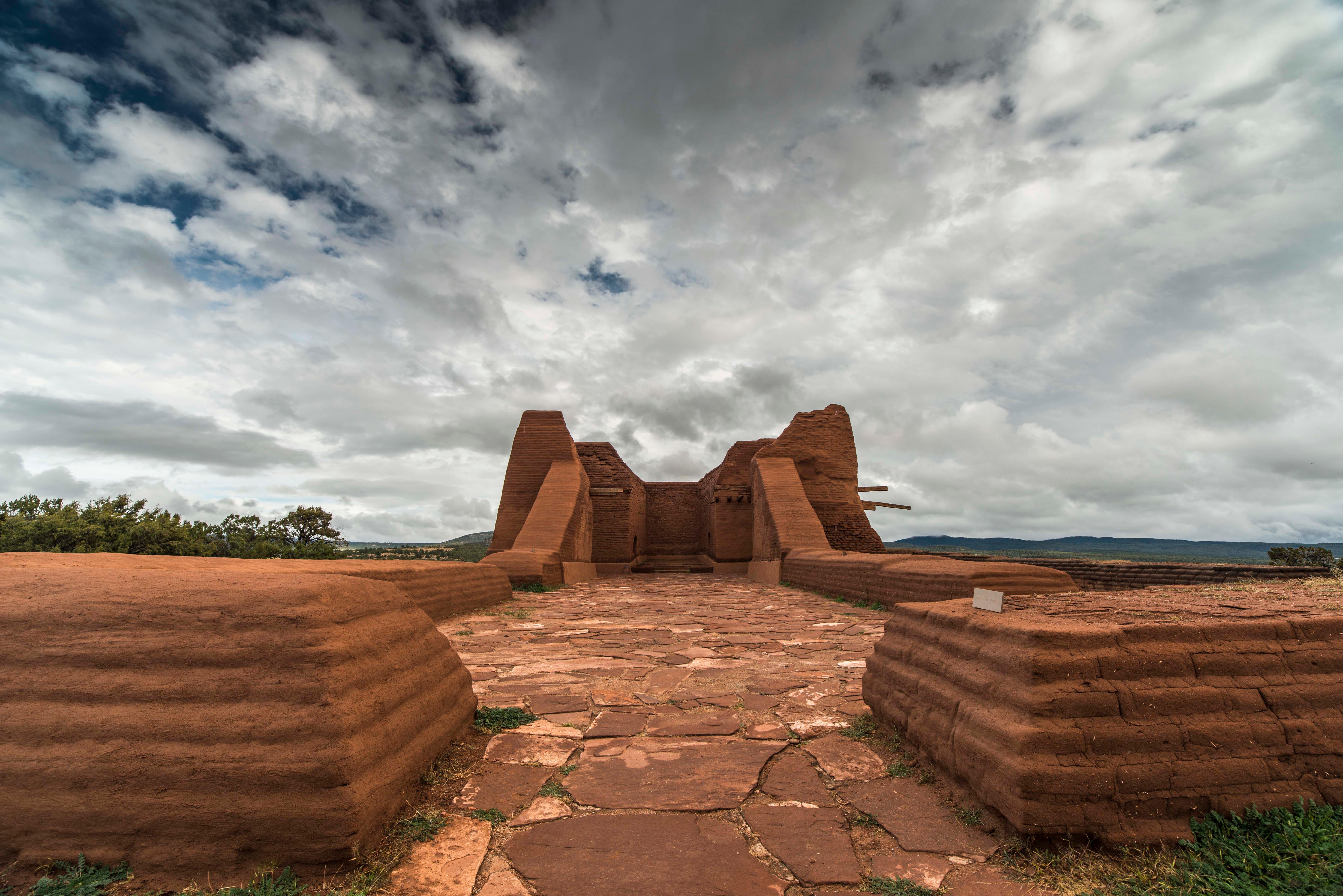 An adobe building under cloudy skies.