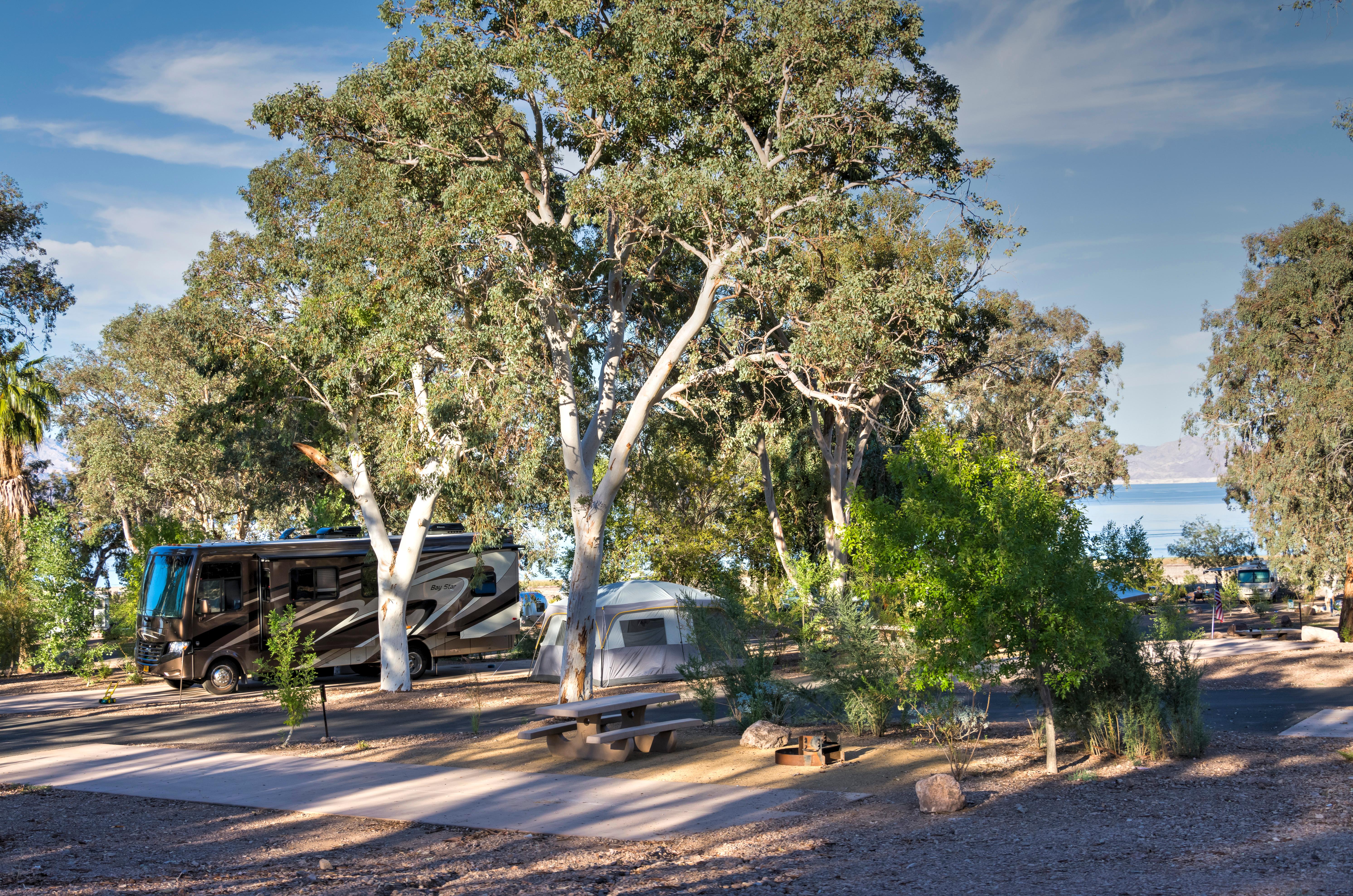 Desert landscape with campsites and two rv's.