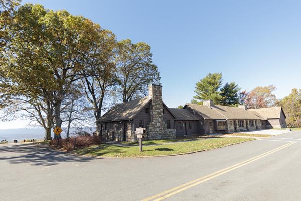 A stone visitor center building beside of a paved road.