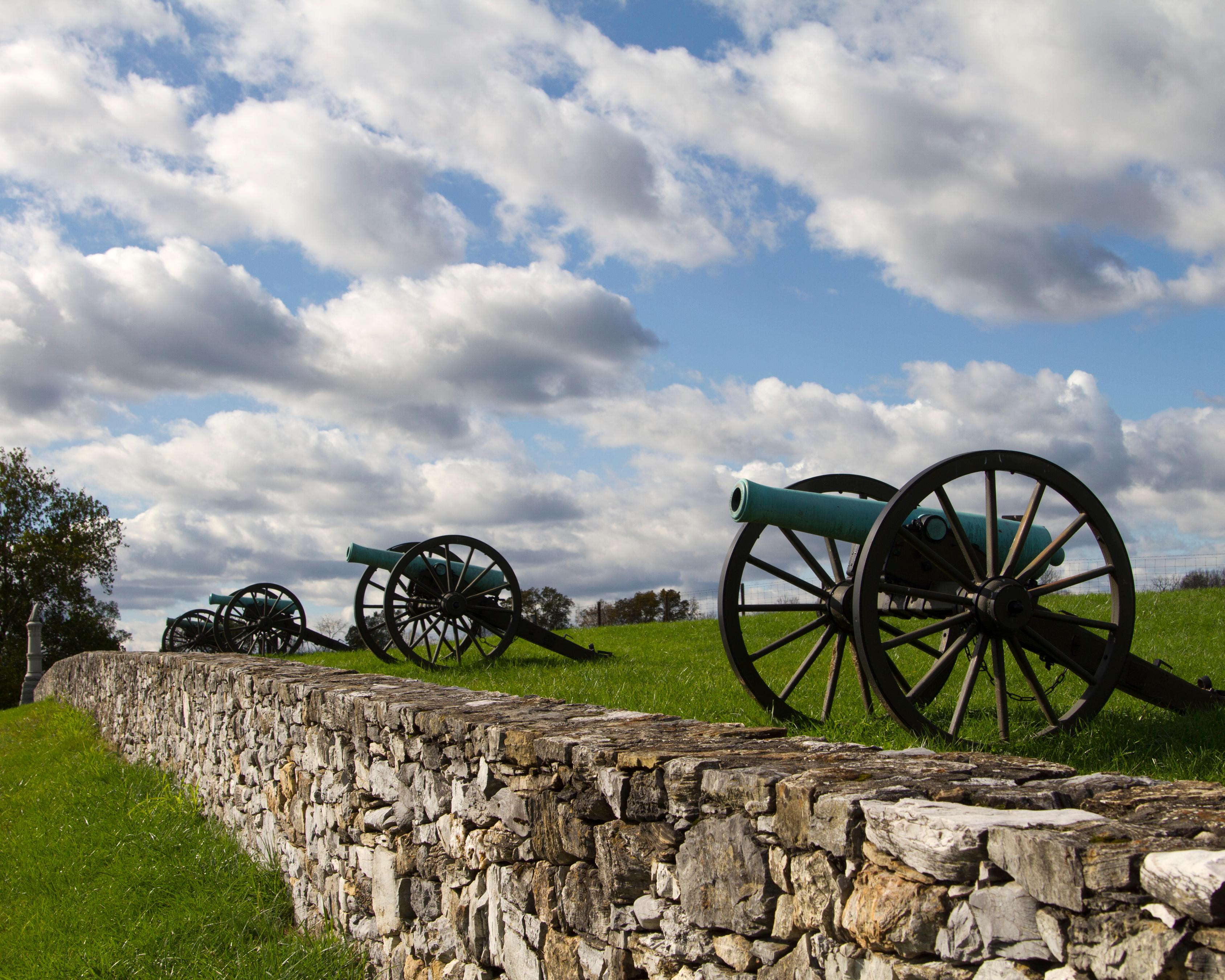 A line Civil War cannons and a stone wall at Antietam National Battlefield