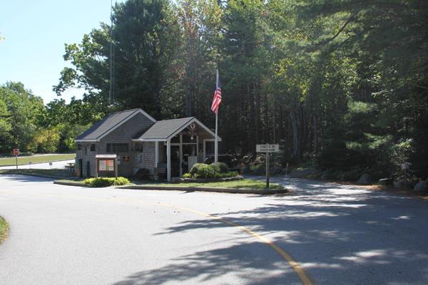 A wooden building with a flag pole and signs