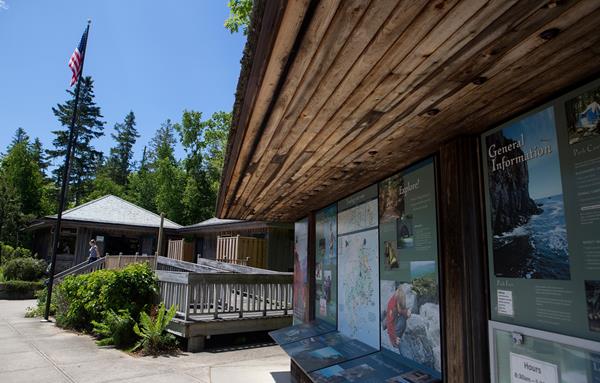 Exterior wooden ramp and bulletin boards outside a brown building