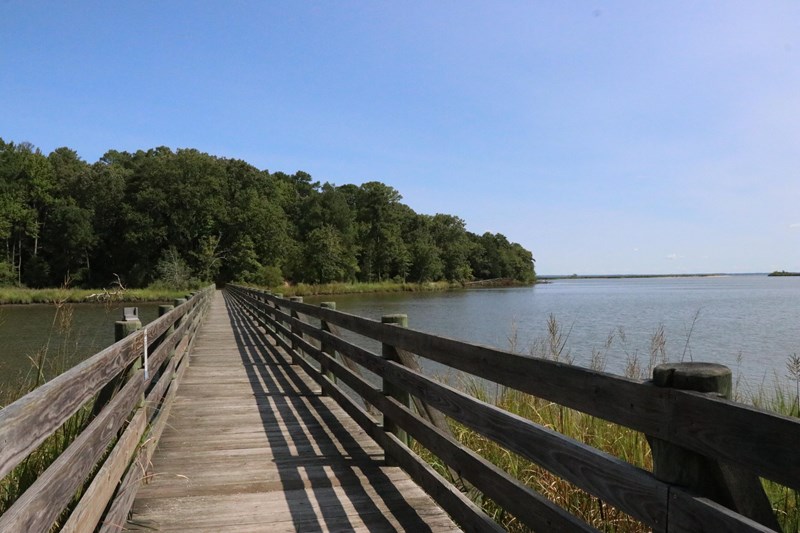 A wooden bridge stretching from shore to shore over a large body of water