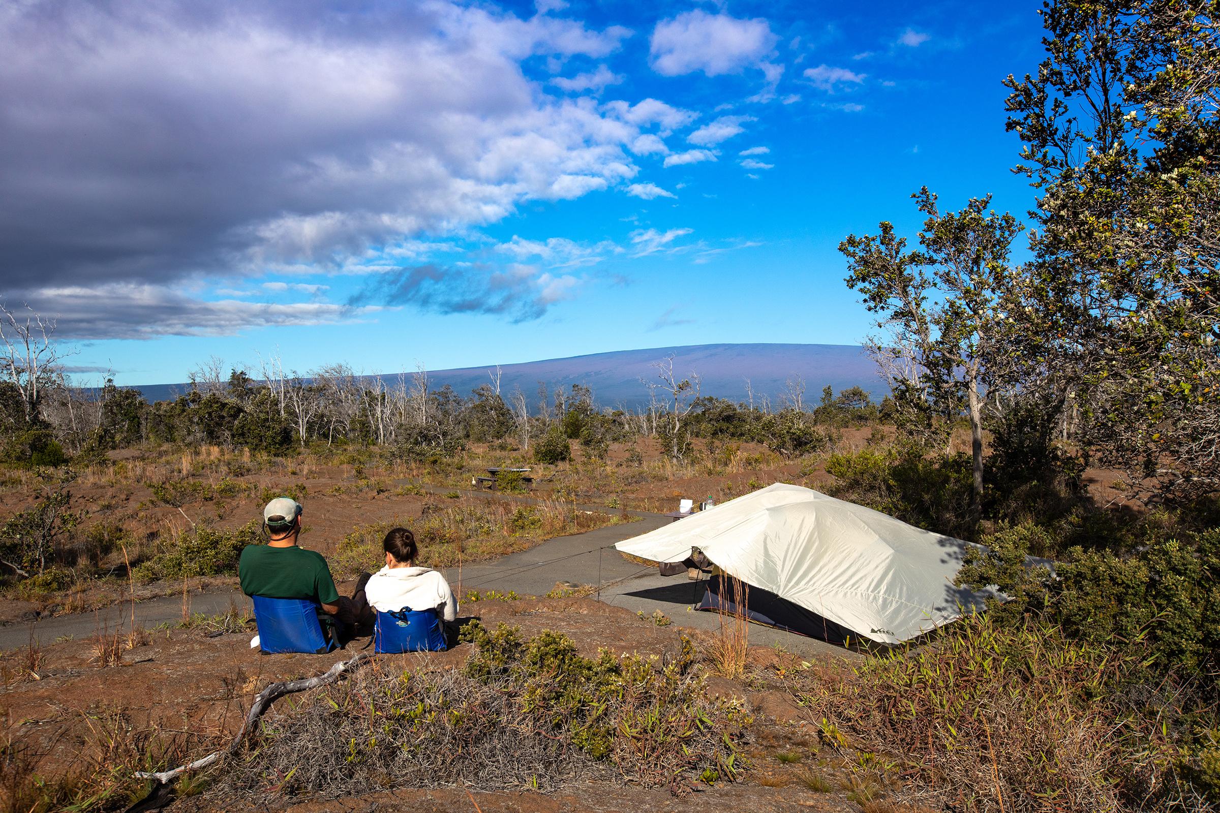 Visitors looking at Mauna Loa from a campsite