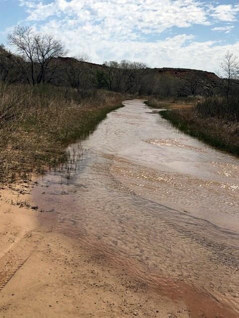 Blue Creek during a wet season.  The water is orange colored and the sky is blue.