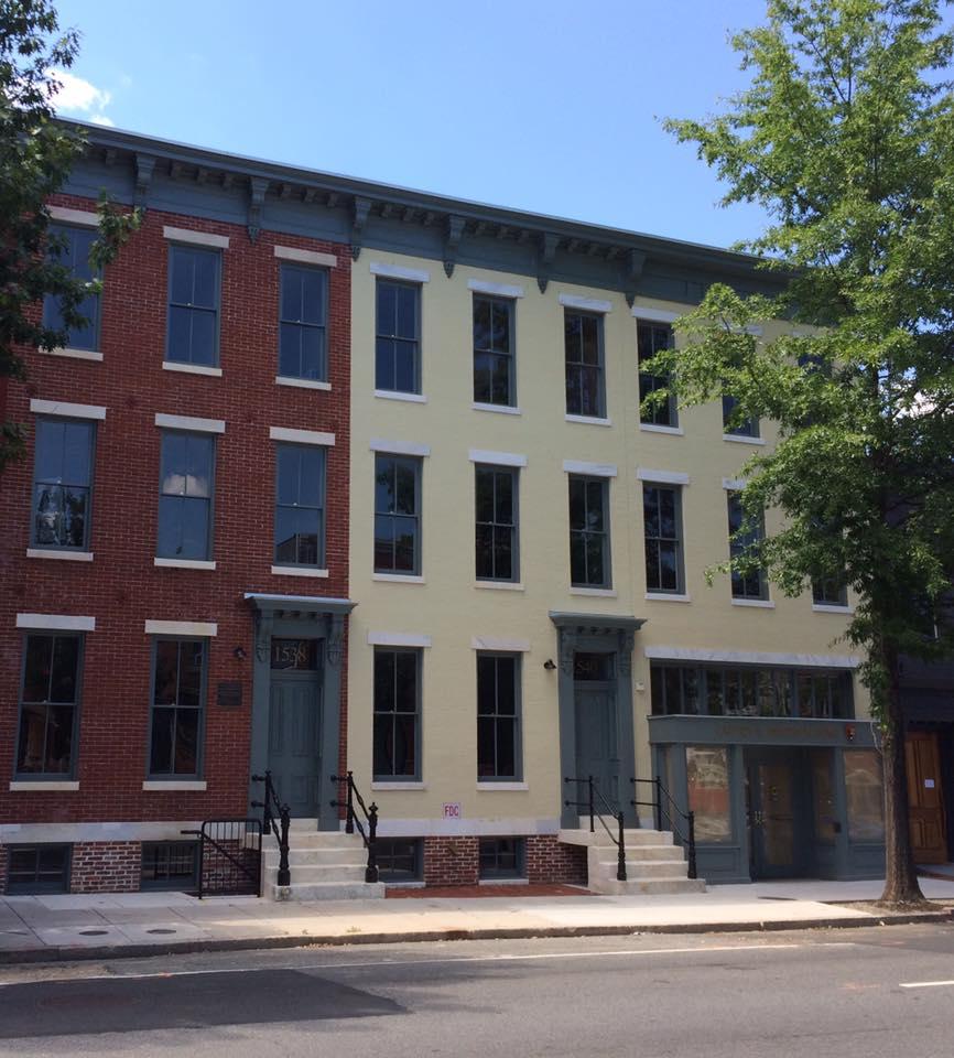 The restored facades of three historic Victorian row-homes on an urban street in Washington, DC