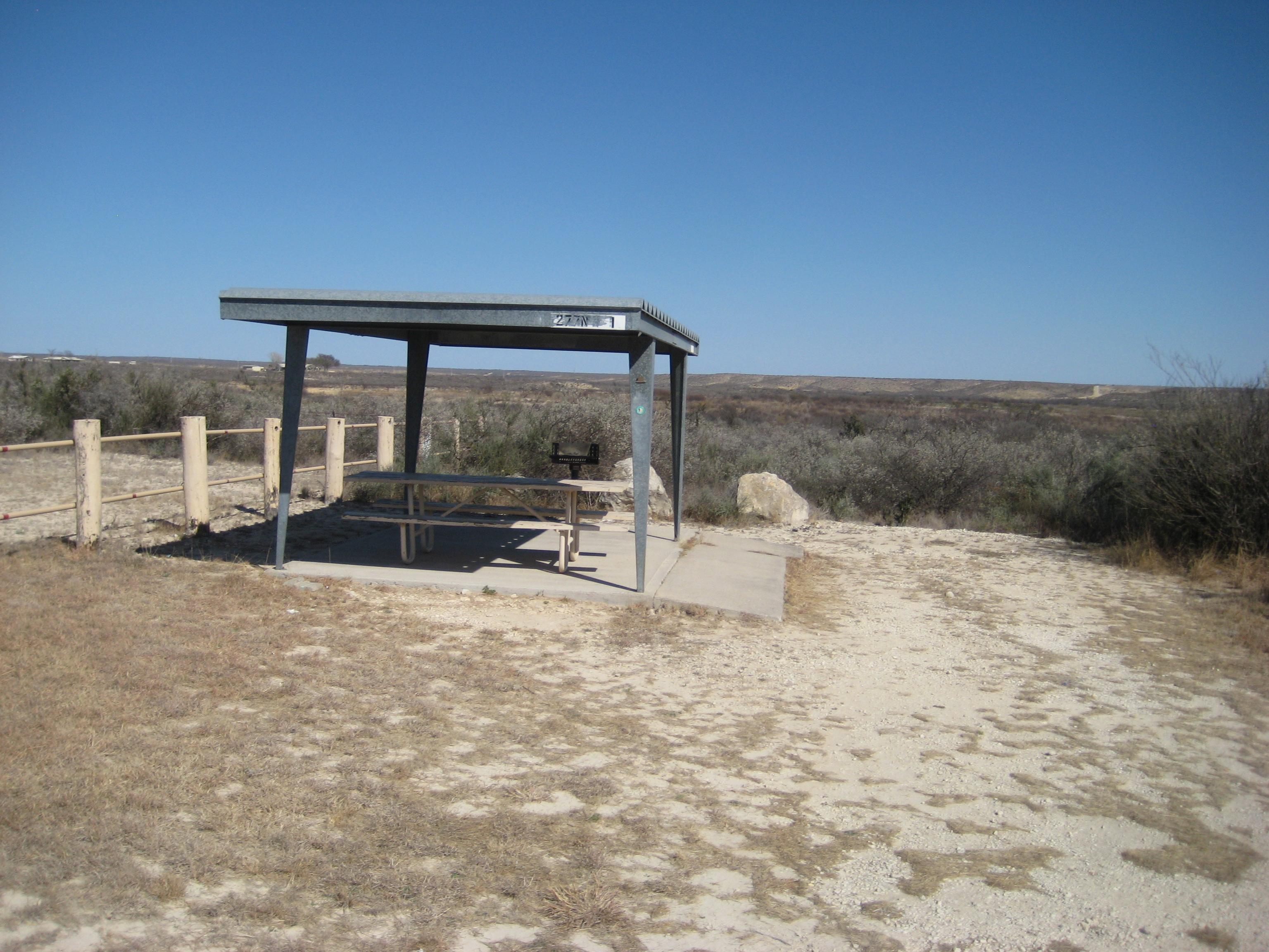 Picnic table under metal shade shelter