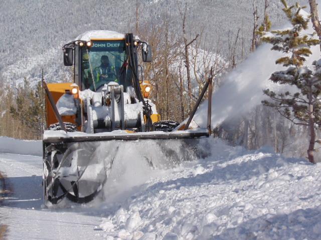 Park crews clear snow from a road using a snowplow