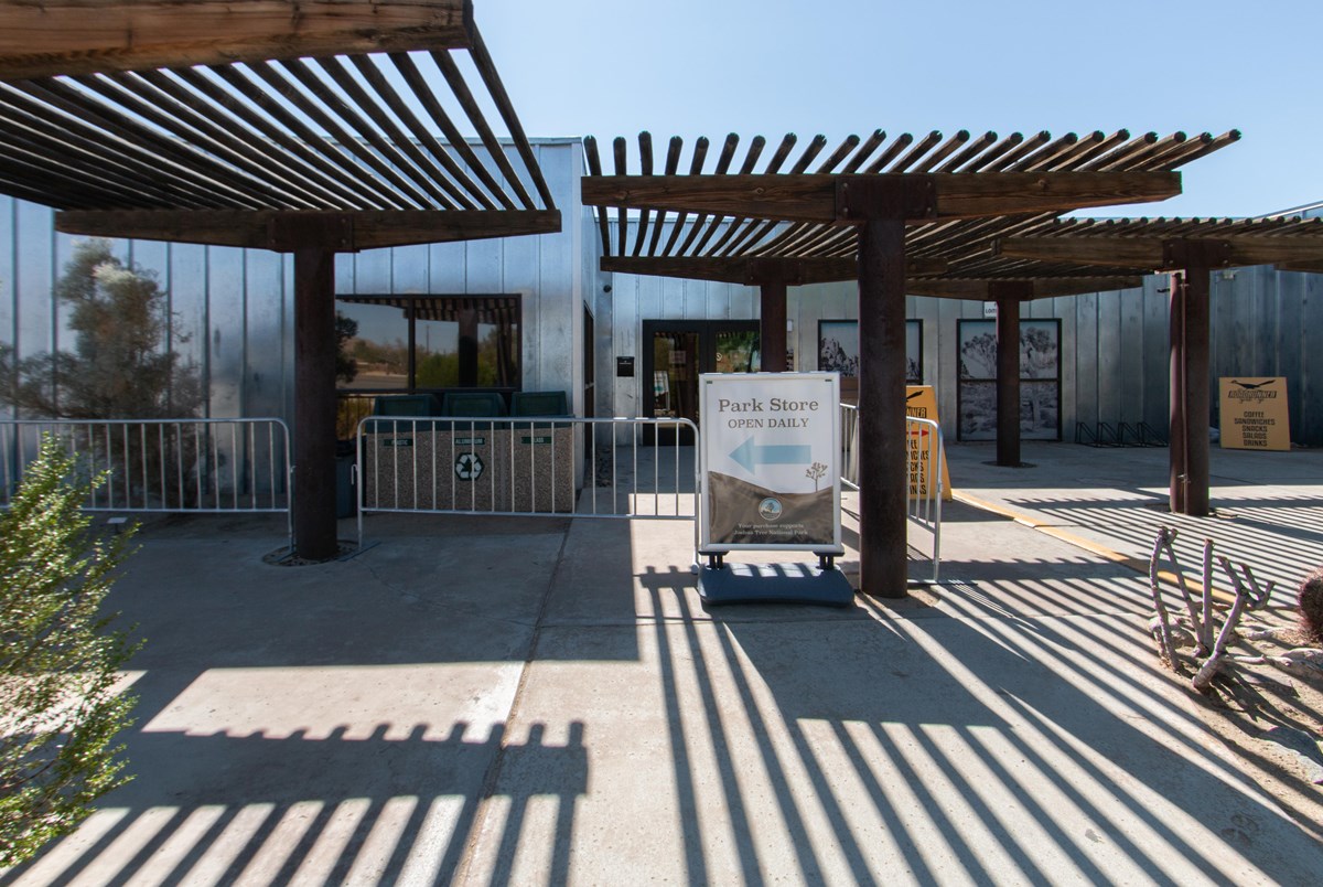 A building with shaded structures and shadows being cast onto concrete floor.