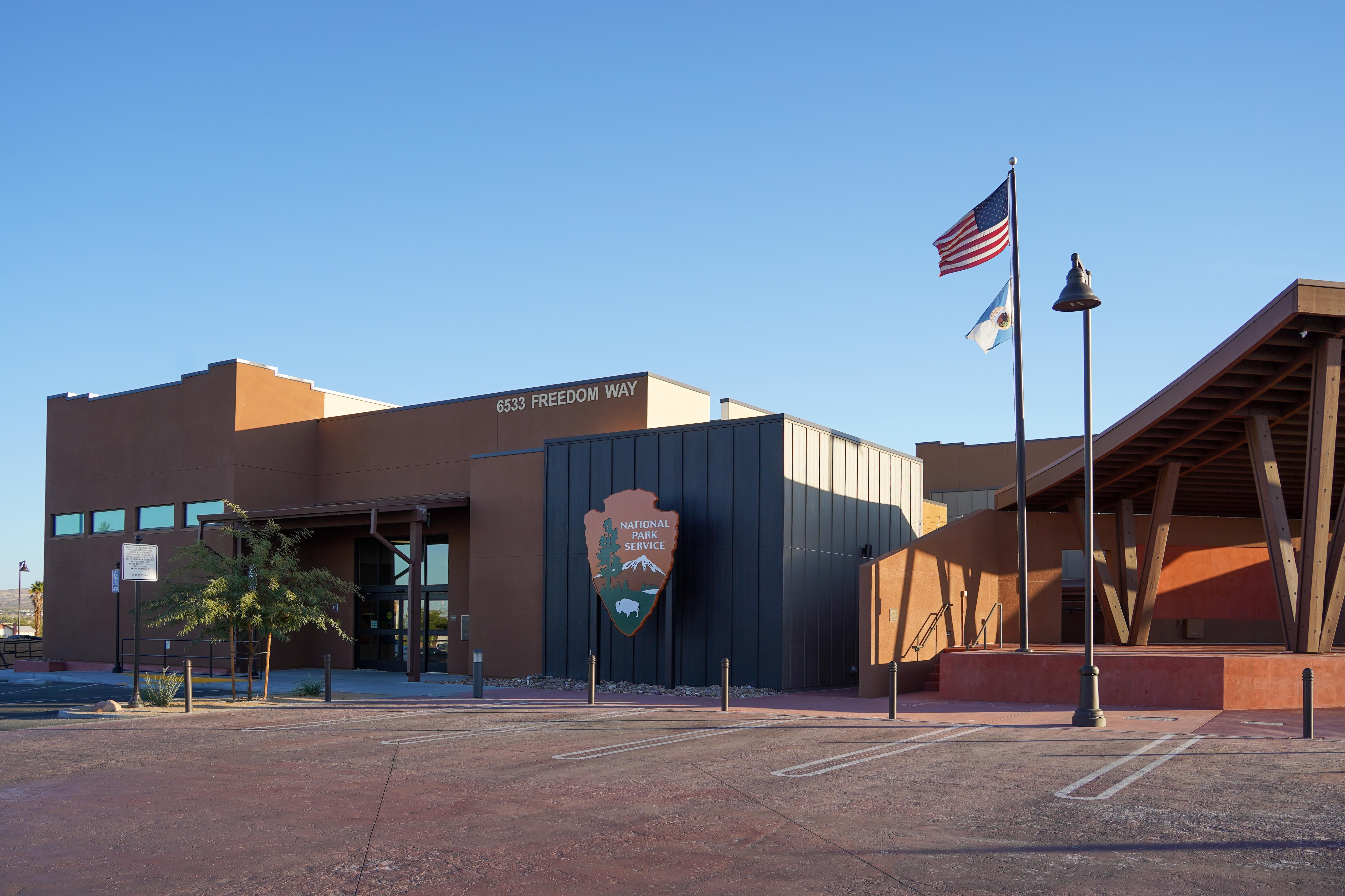A building and parking lot with a large National Park Service arrowhead on the front.