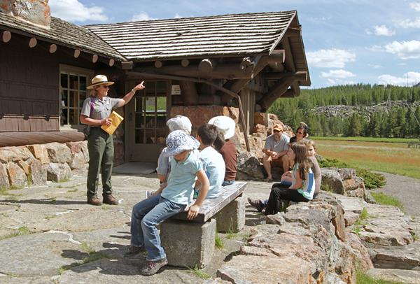 A park ranger talks to visitors on the stone patio of the Madison Information Station