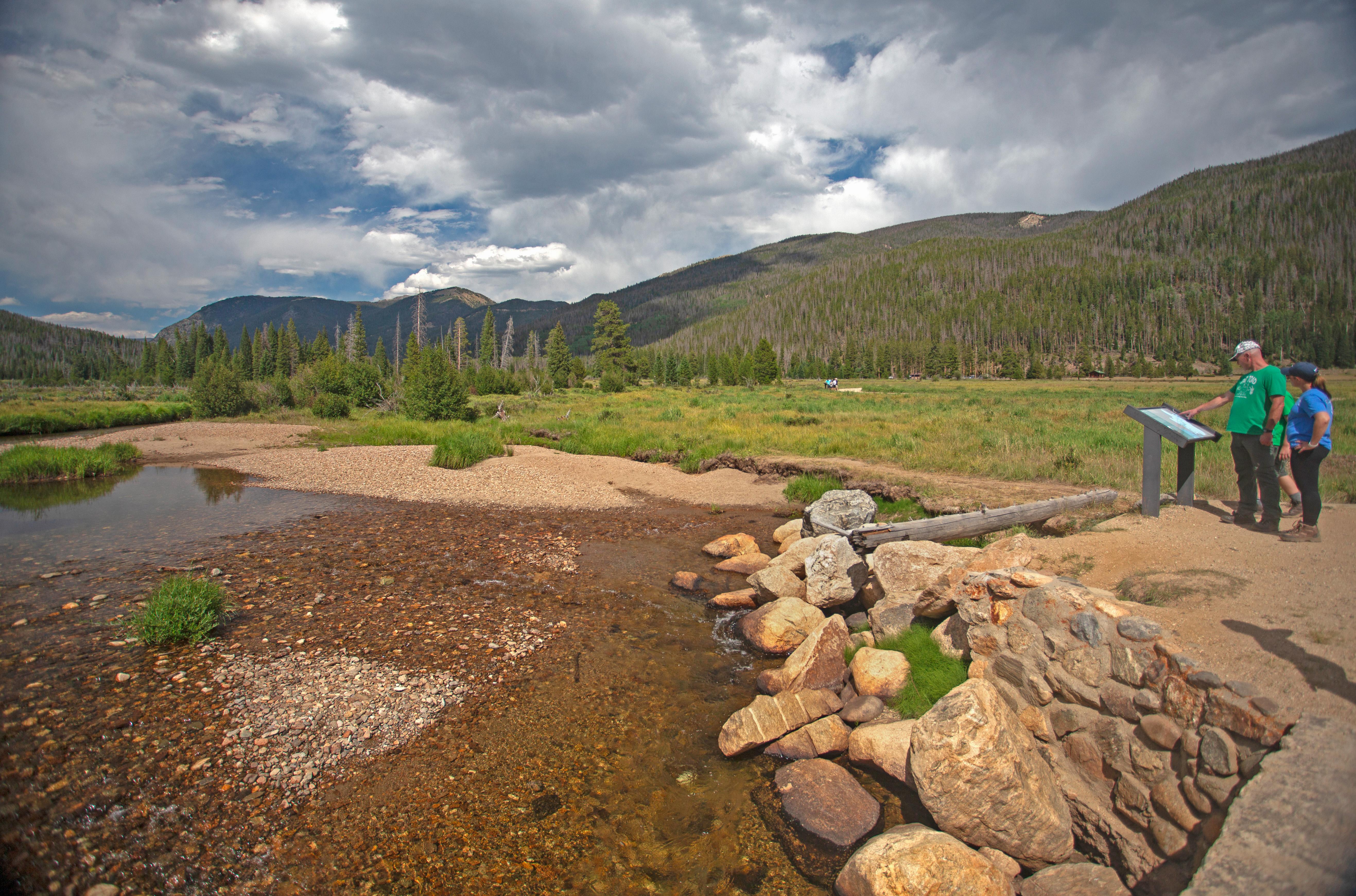 Two visitors are looking at the Colorado River along the trail to the Holzwarth Historic Site