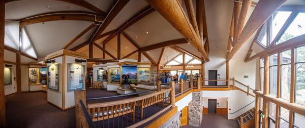 a wide angle of the visitor center - a staircase, museum panels, and a ram statue are visible