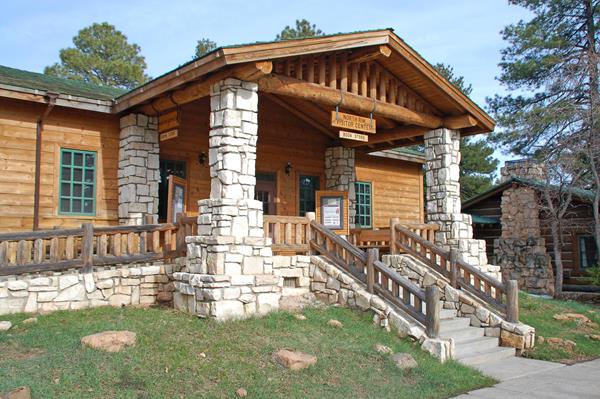 stairway to rustic building of wood with stone entrance pillars supporting covered porch.