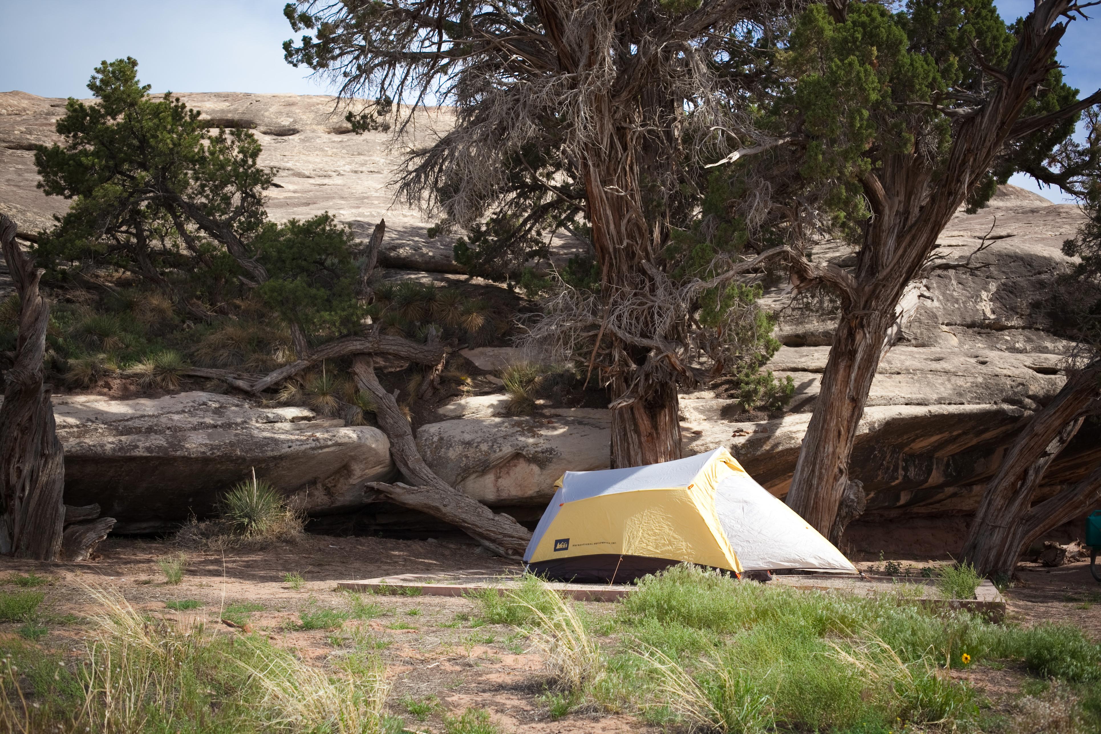 a yellow tent nestled against a rock outcropping