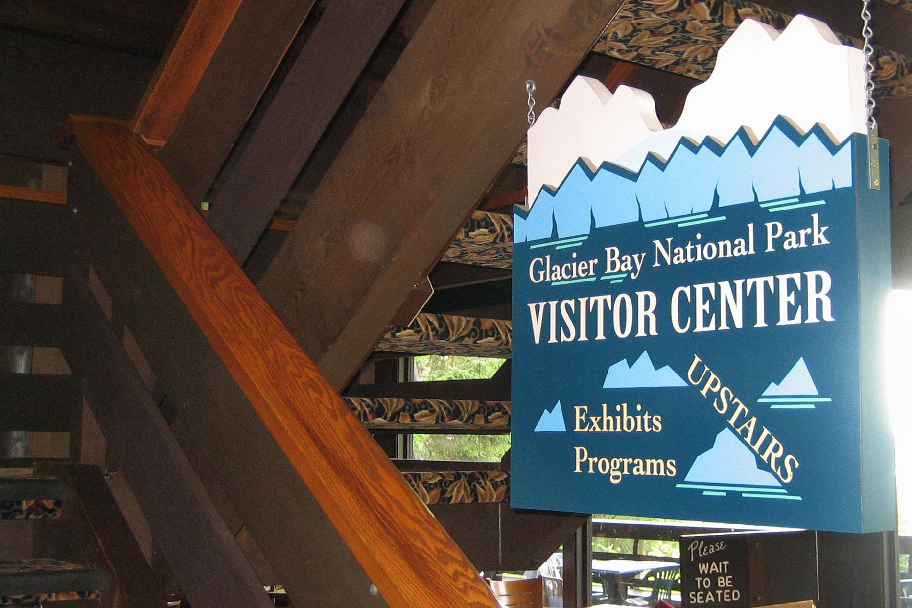 A sign indicates that the Glacier Bay National Park Visitor Center is located upstairs in the lodge.