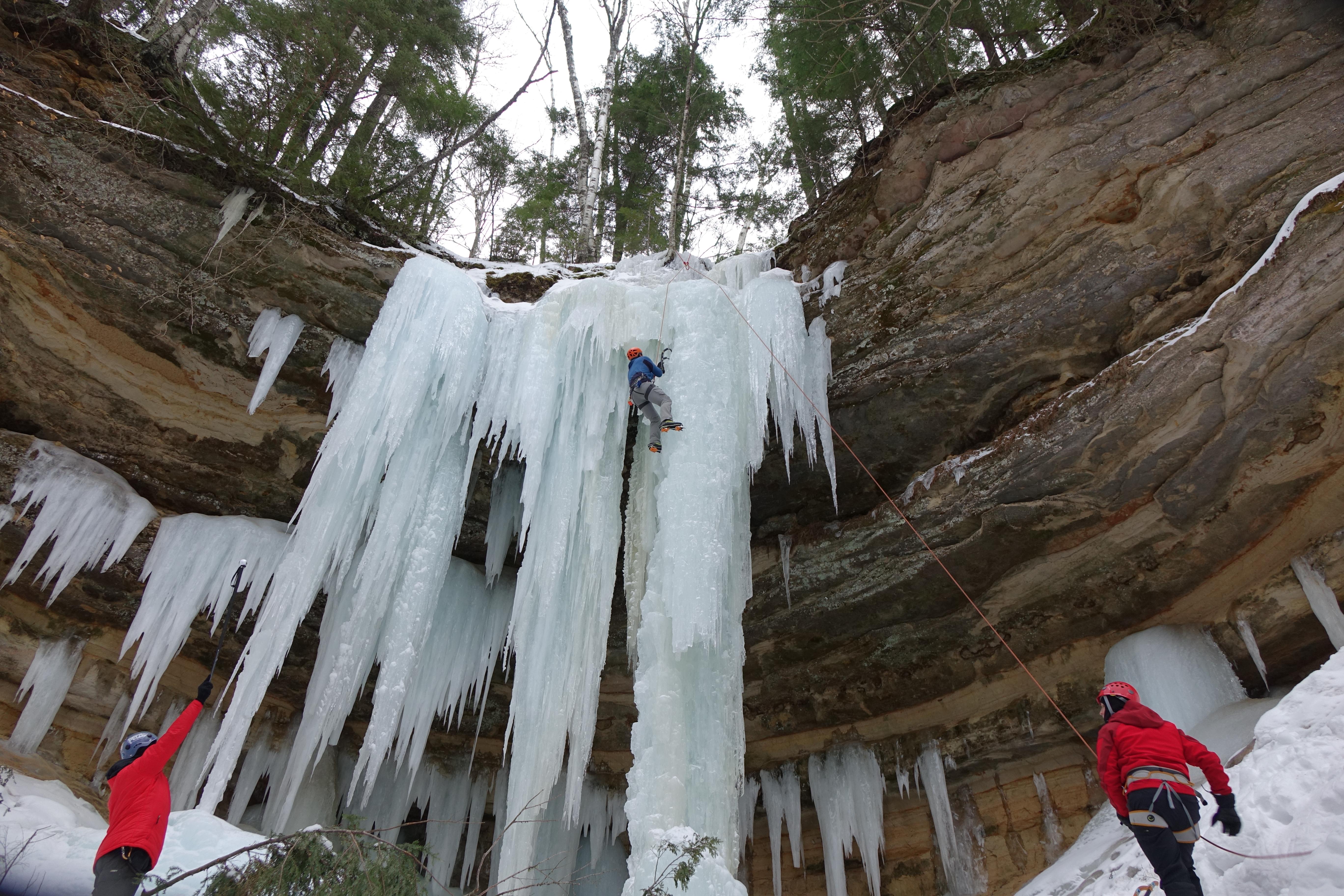 Ice climber on a curtain of ice along the Pictured Rocks Escarpment