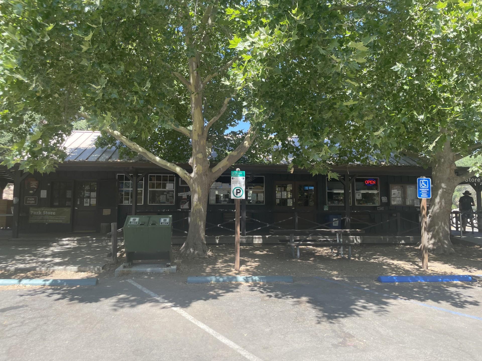 View of a wooden campground store from a parking lot