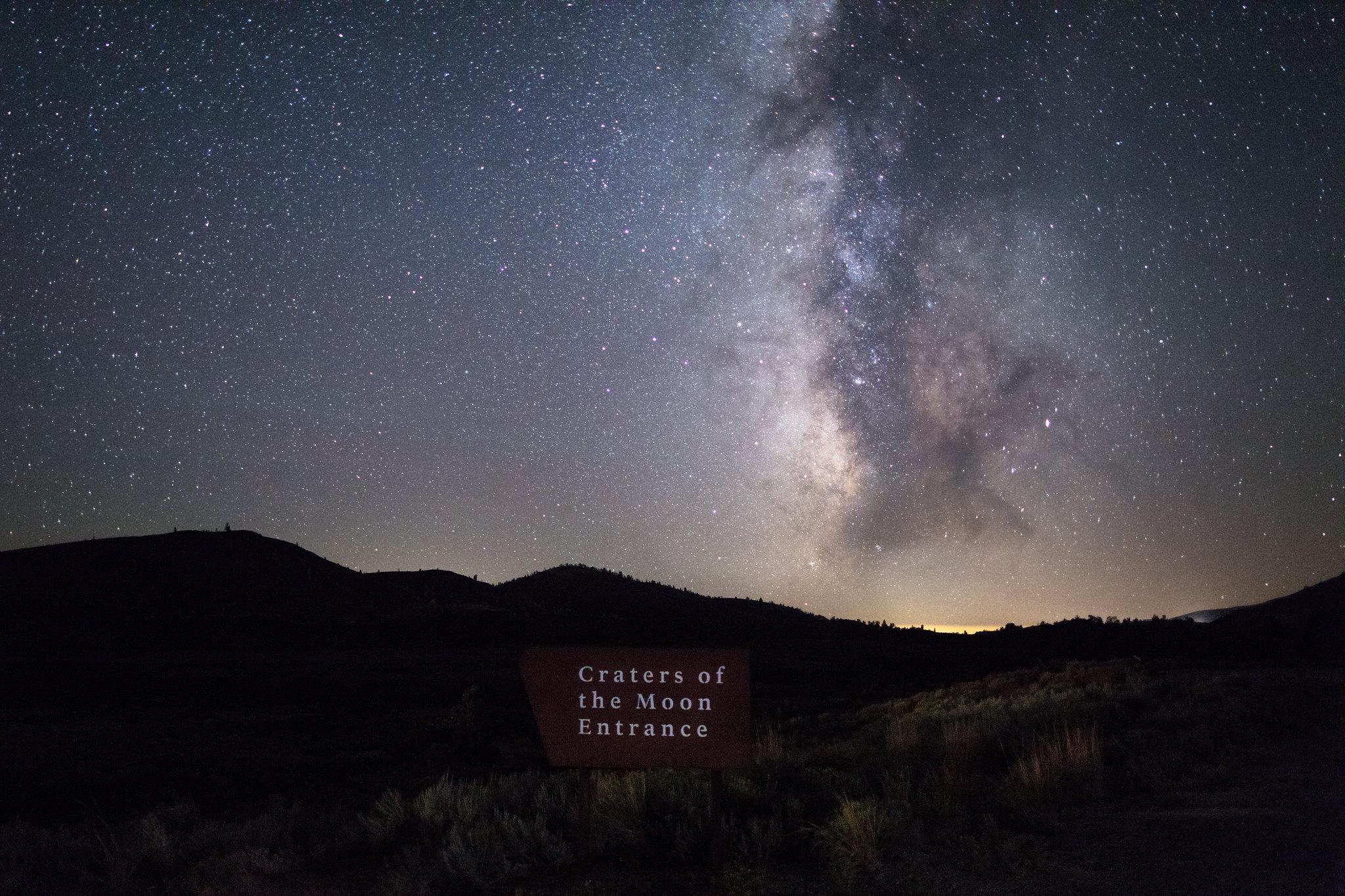 The Craters entrance sign sits below a starry night sky, with the milky way brightly-lit.