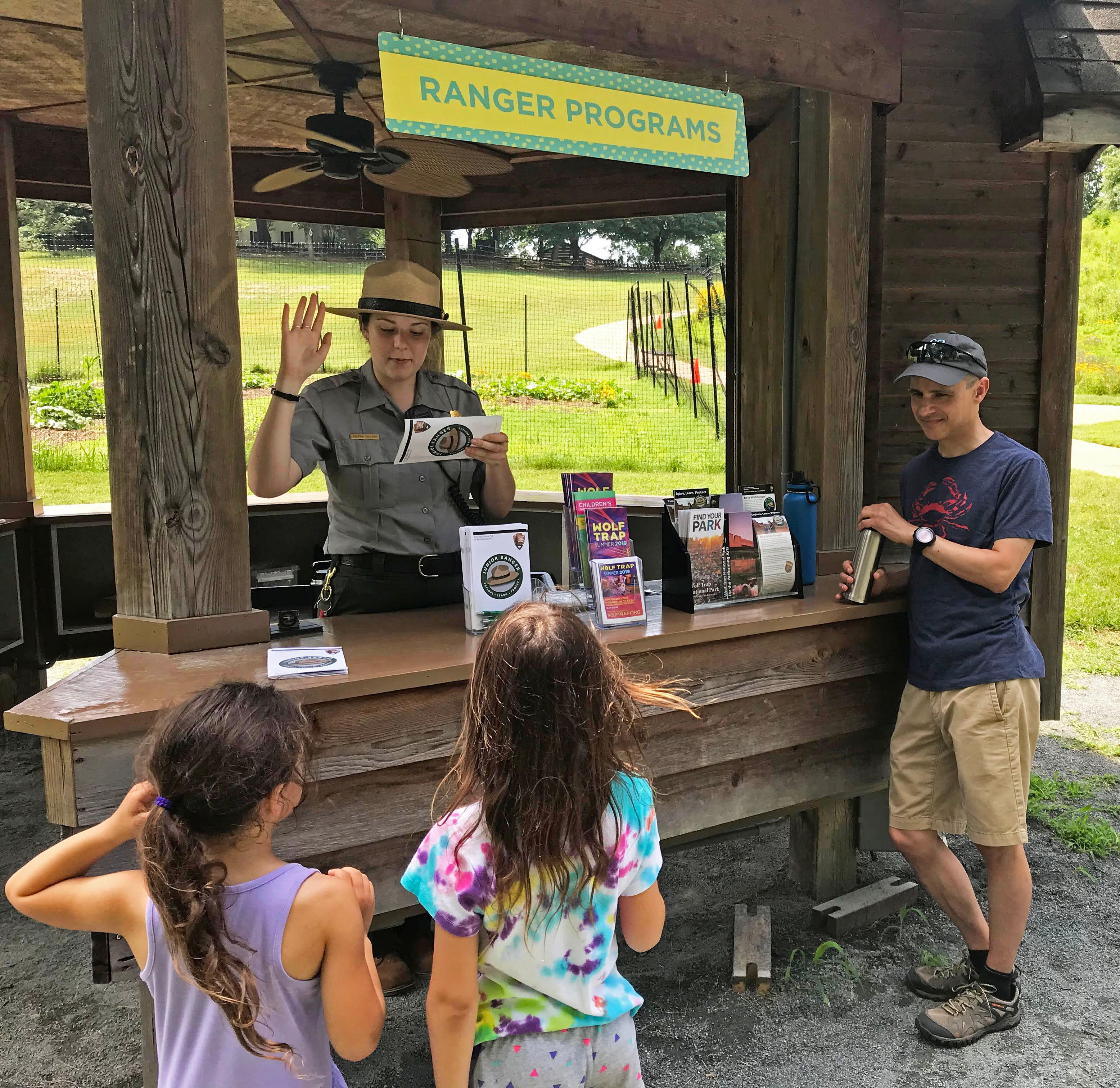 A ranger swears in two new Jr. Rangers during Jr. Ranger Day activities at the park.