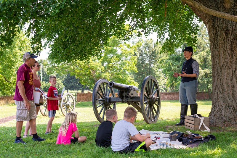 Living History on Marye's Heights A living historian dressed as a US Civil War soldier speaks with a family outdoors.