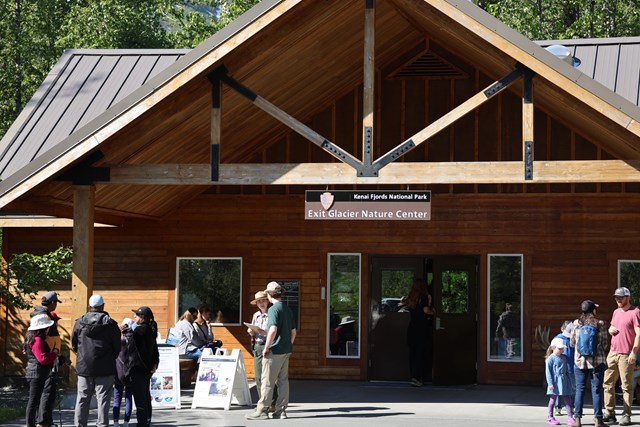 The front of a brown colored building with visitors outside