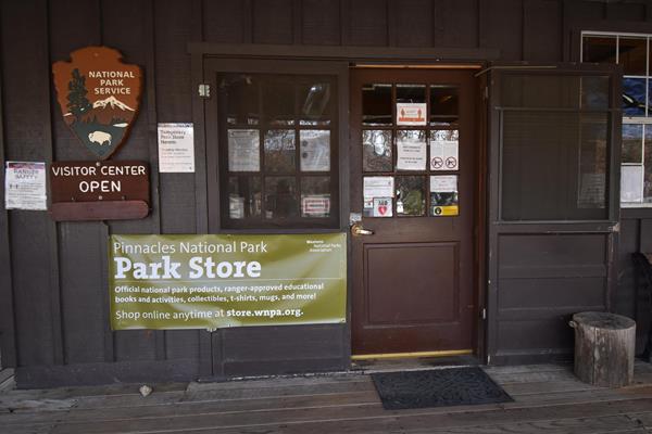 Photo of a door with a banner next to it that reads "Pinnacles National Park, Park Store"