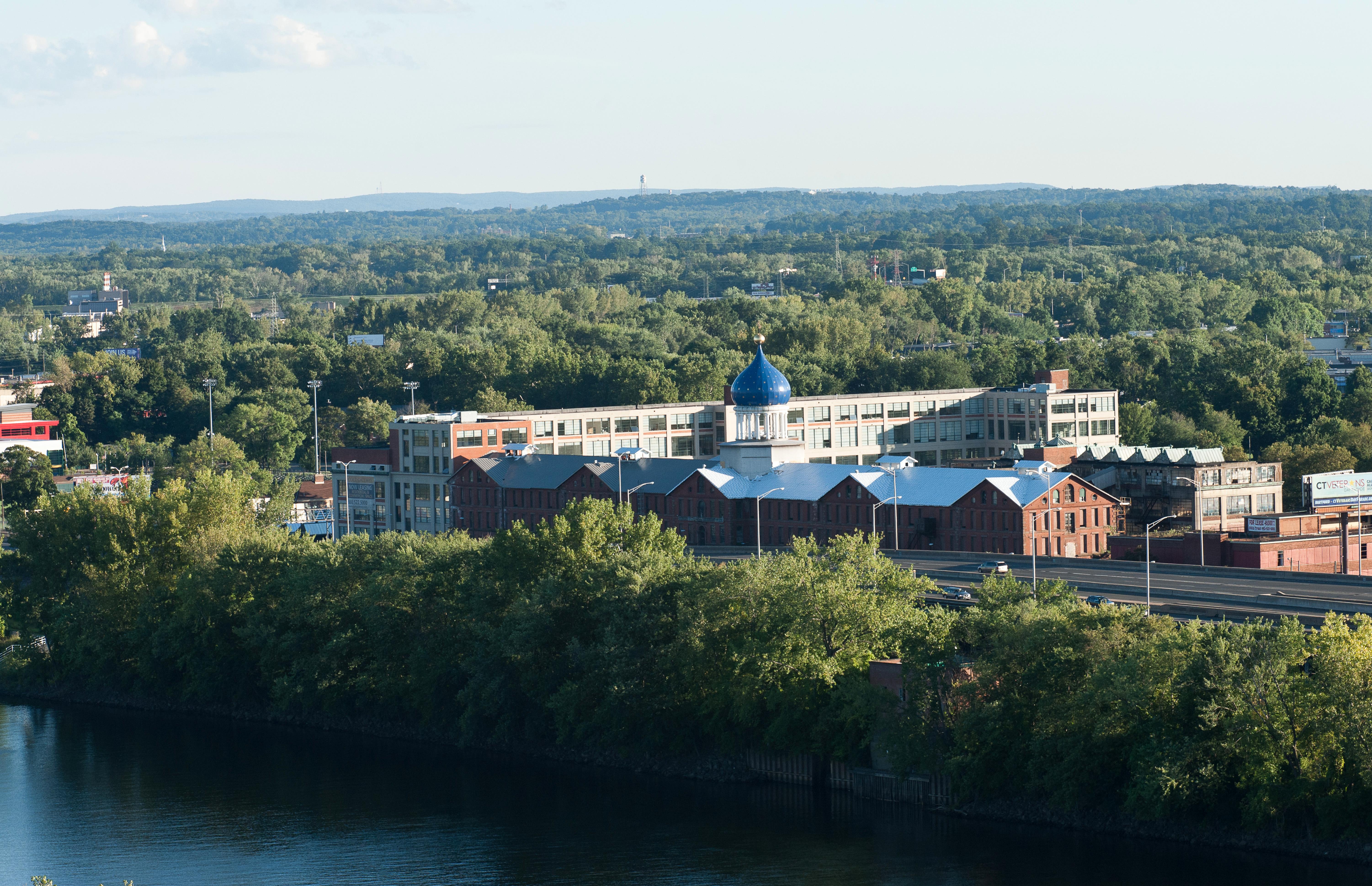 Blue dome atop a large factory behind a river