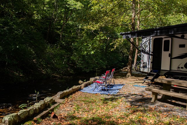 Lawn chairs posted beside a calming creek.