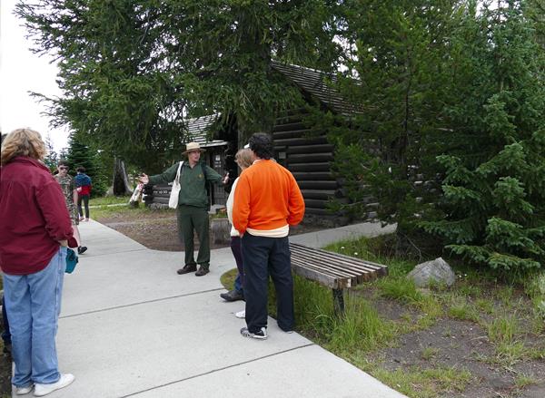 A ranger gives a program to visitors in front of West Thumb Information Station.