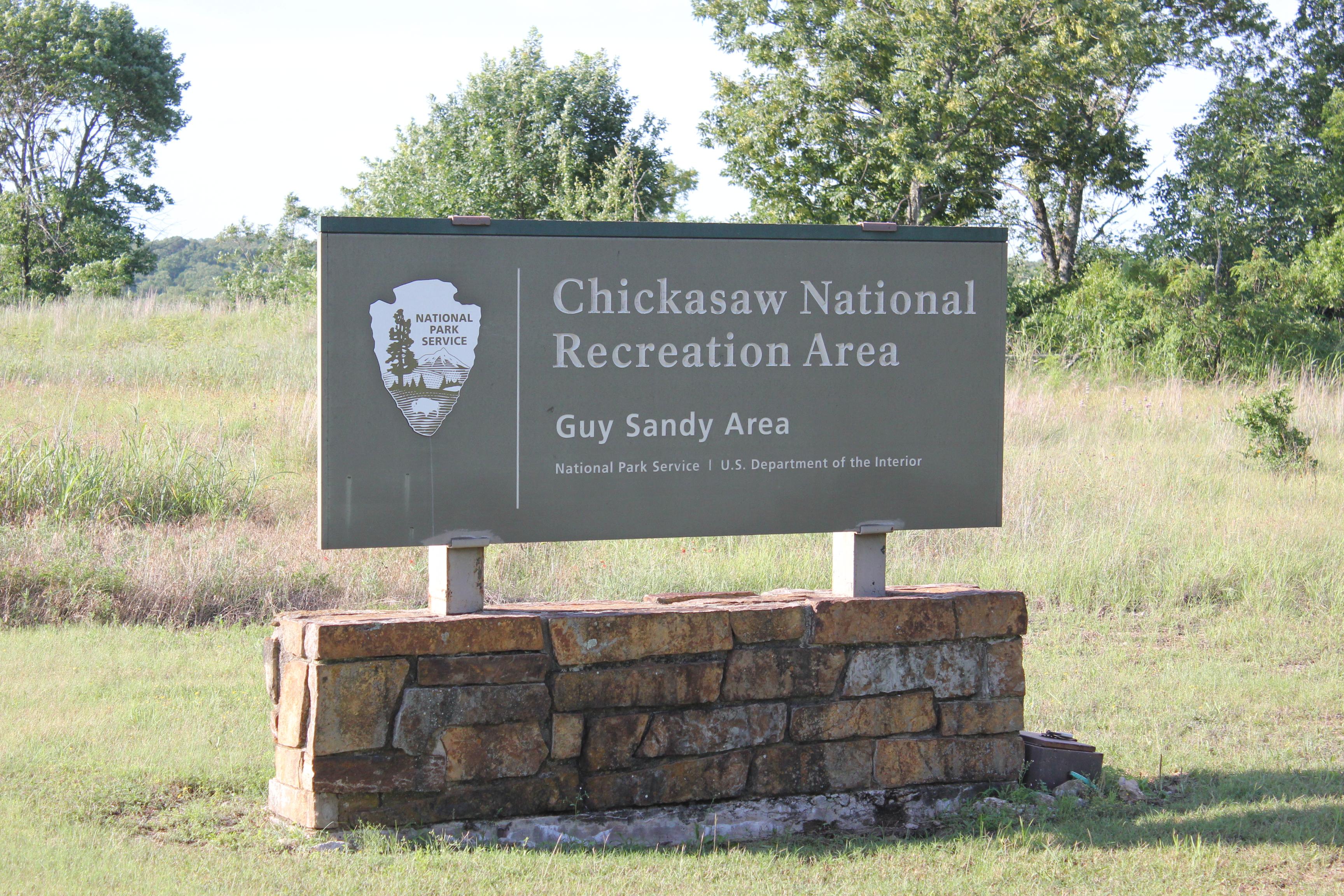 A park entrance sign for the Guy Sandy area at Chickasaw National Recreation Area