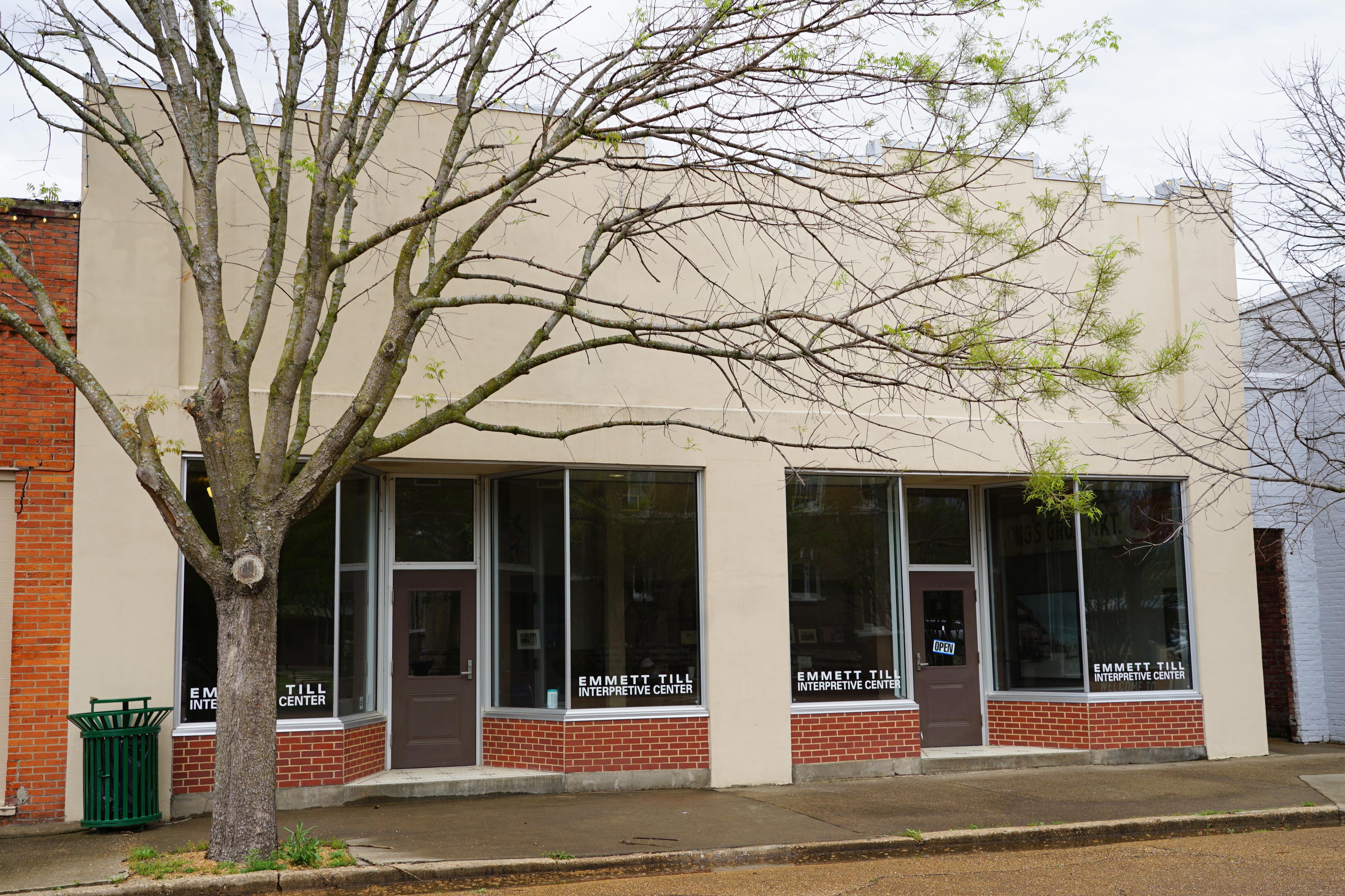 A one story store-like front along a street containing two doors and several windows.