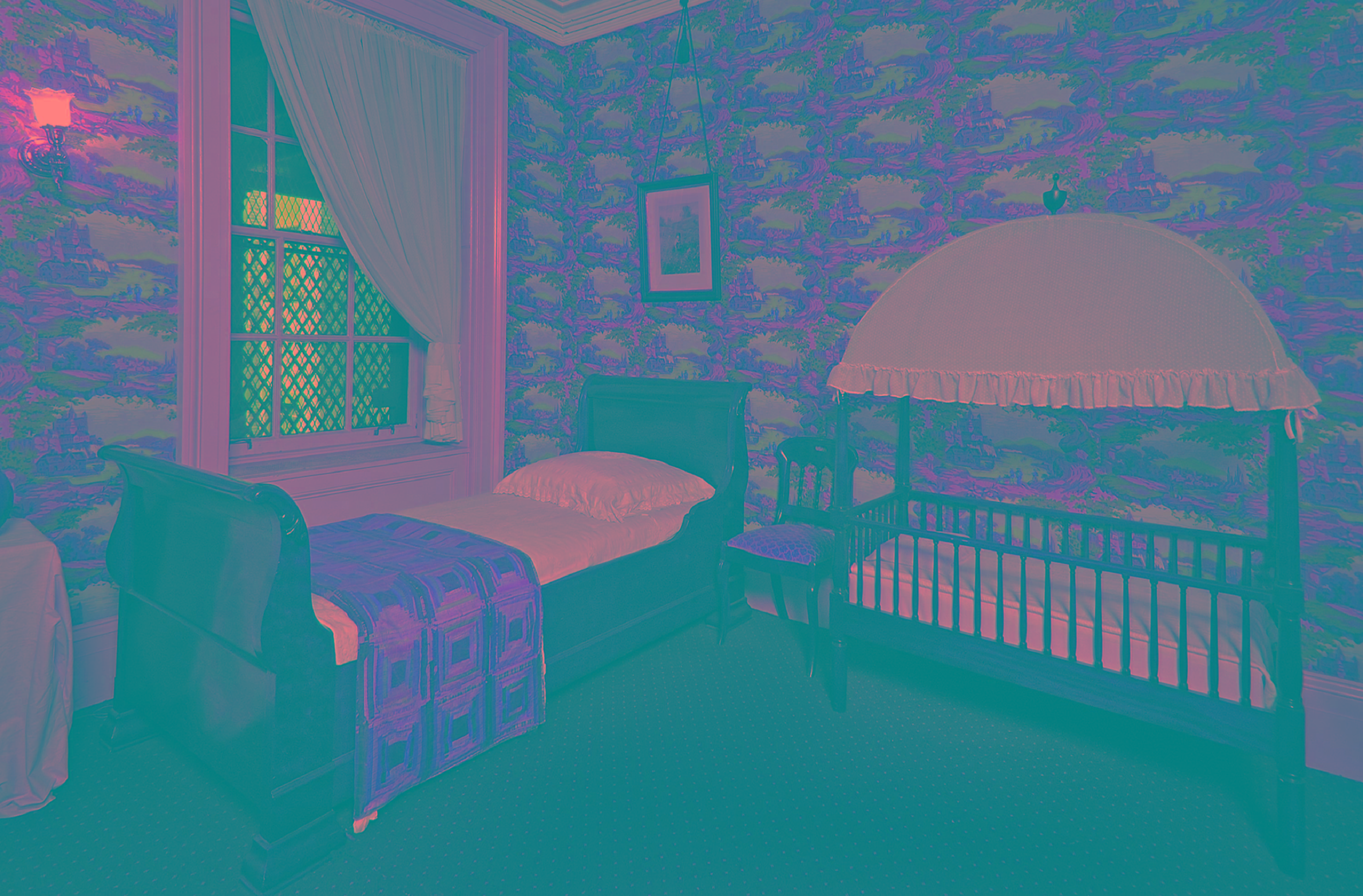 colored photograph of nursery with a sleigh bed and crib adjacent to bed.