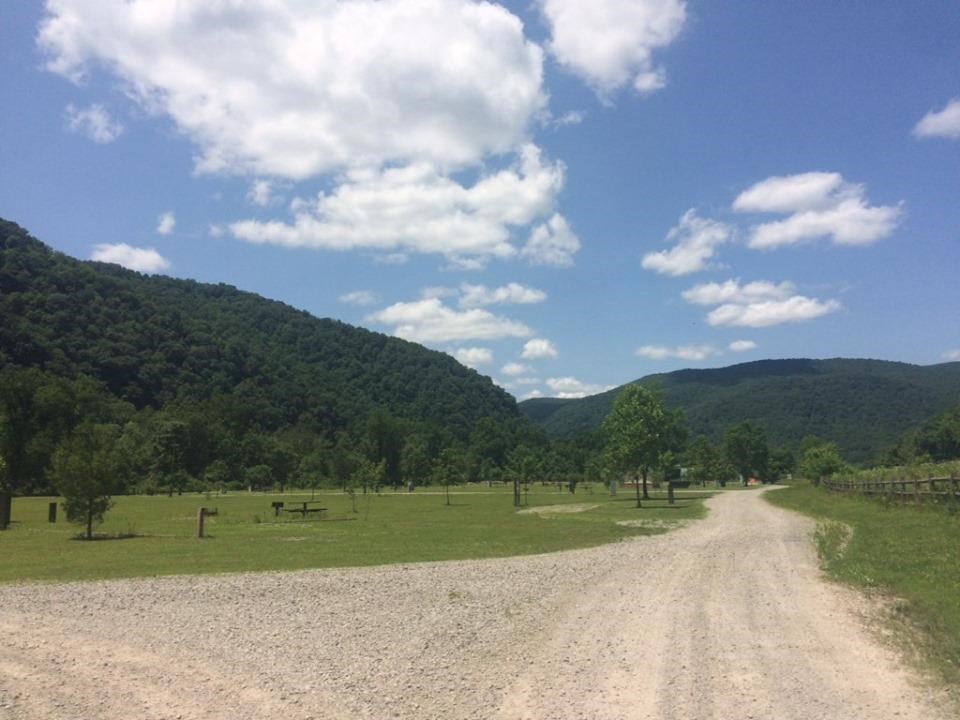 dirt road entering into large grassy campground