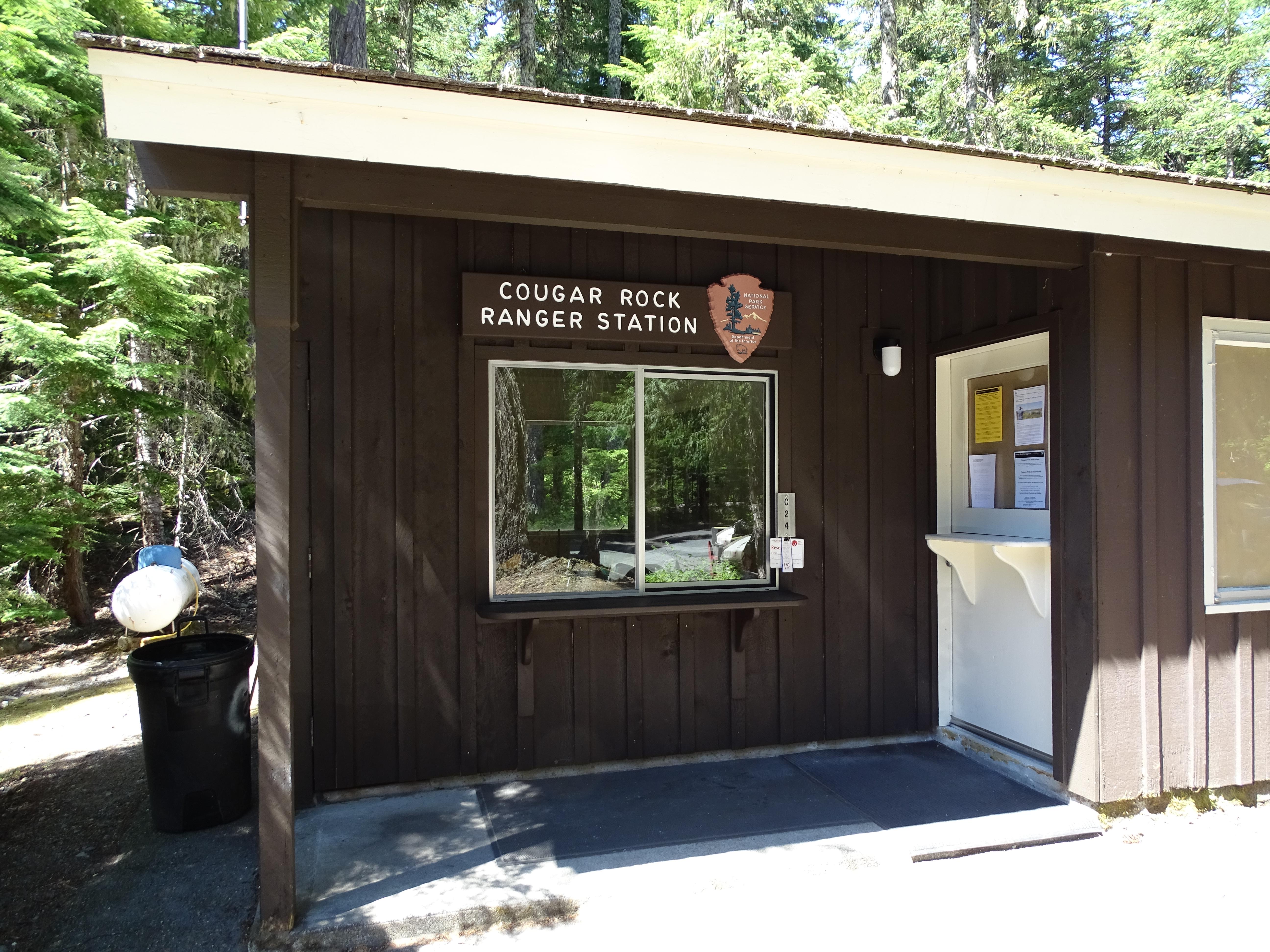 A small brown building with a window for taking questions.