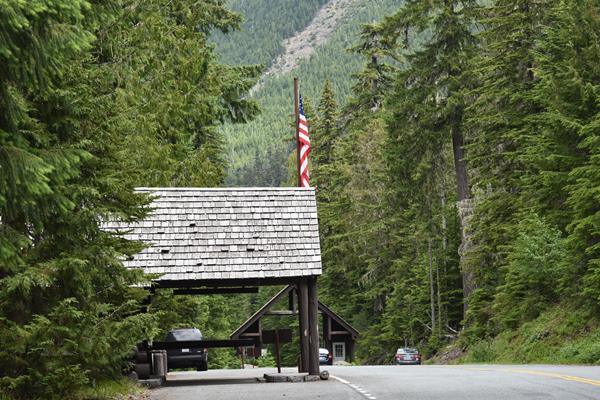 The shingled porch of a rustic building with an entrance in the background.