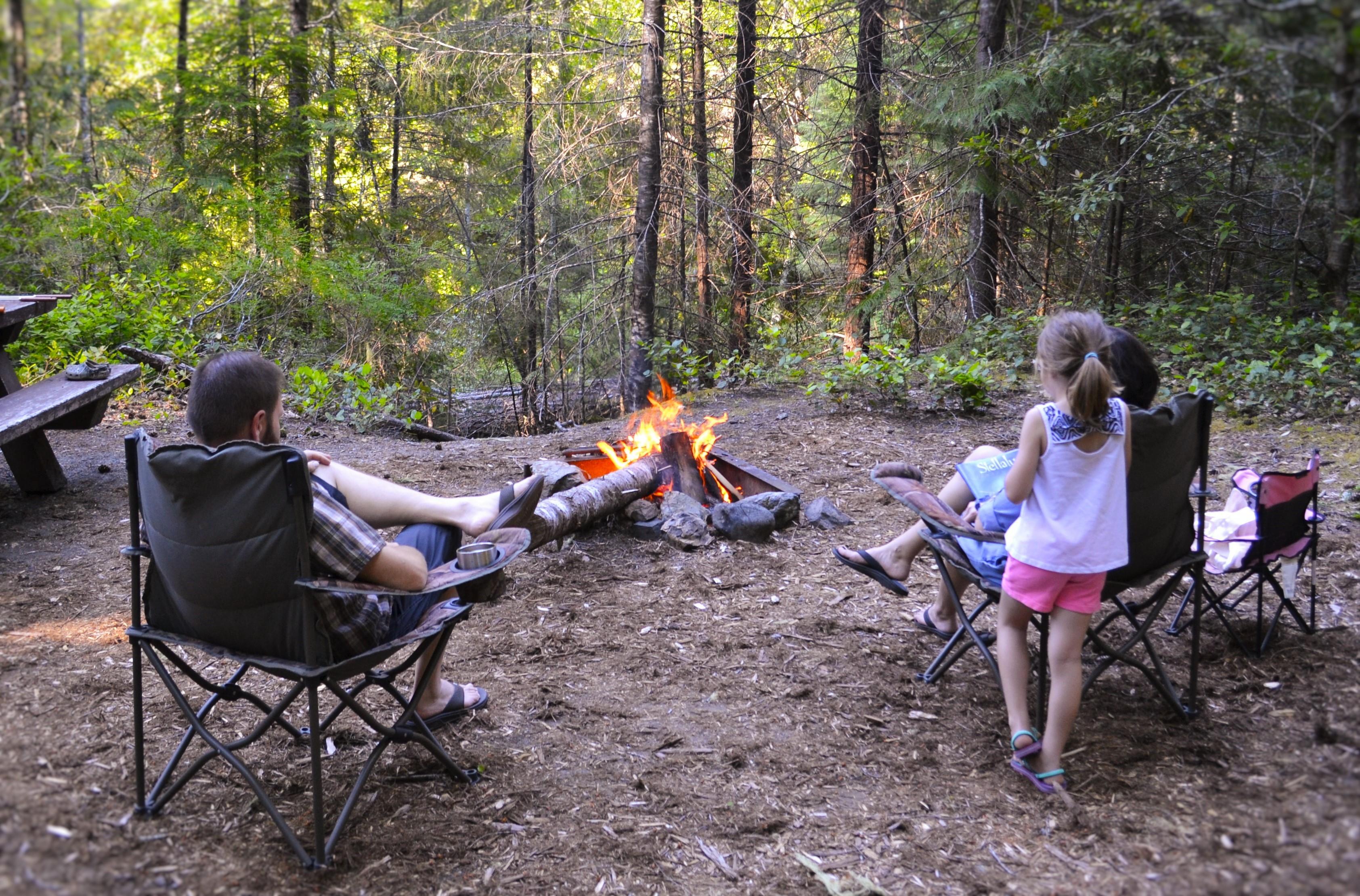 Family sitting around a campfire at Cave Creek Campground