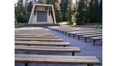 long benches with a center walk face a raised amphitheater structure with screen
