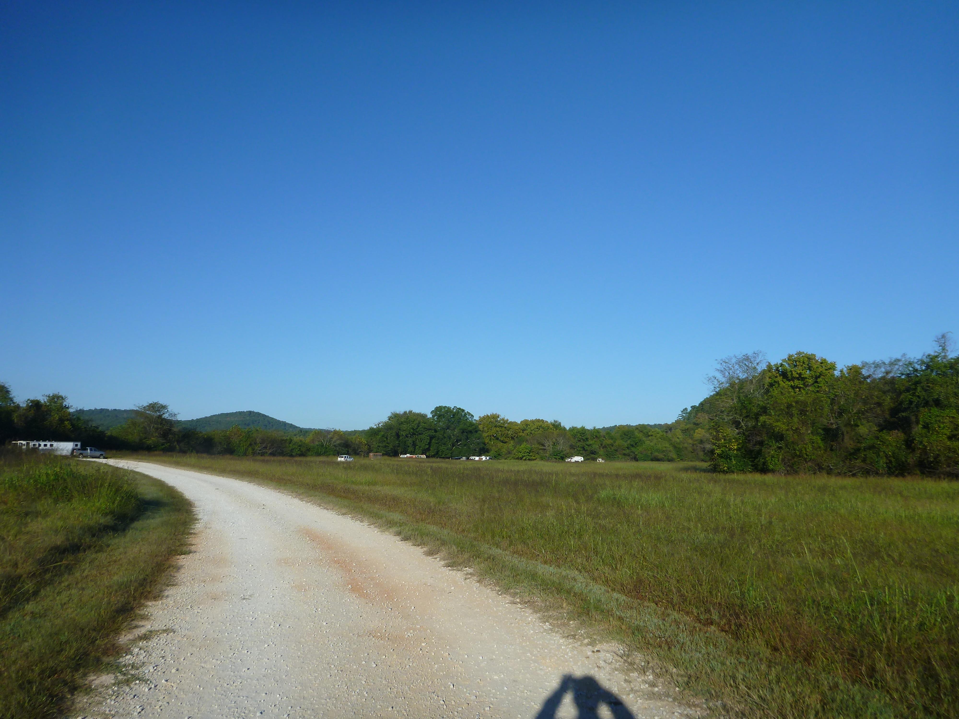 green field with campers in the distance