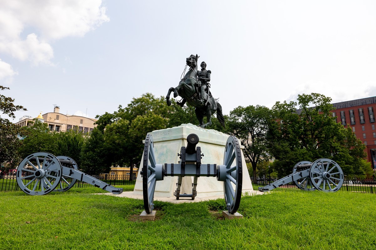 A bronze statue of Andrew Jackson on horseback surrounded by cannons