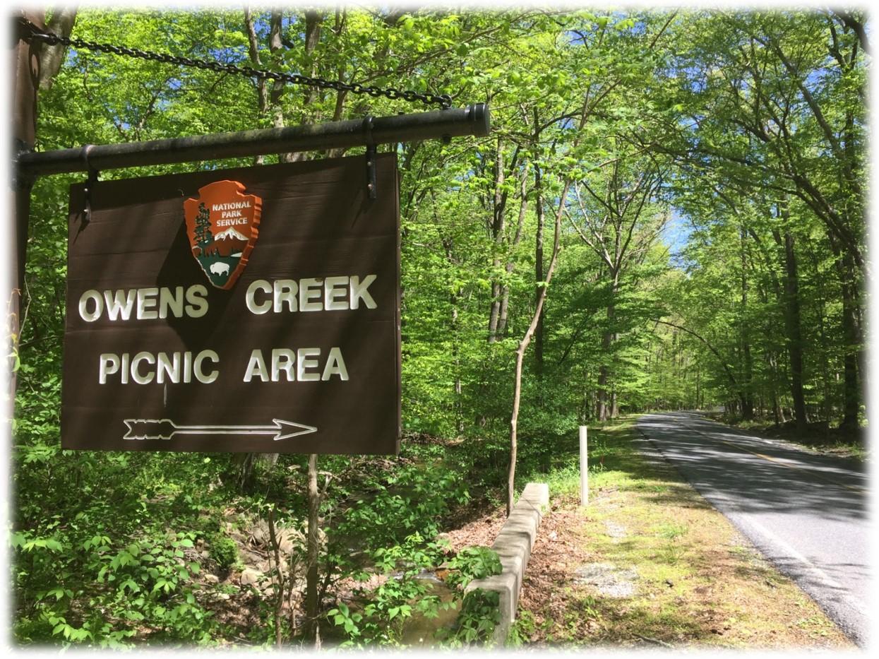 Wooden Sign with direction sign and the words Owens Creek Picnic Area 