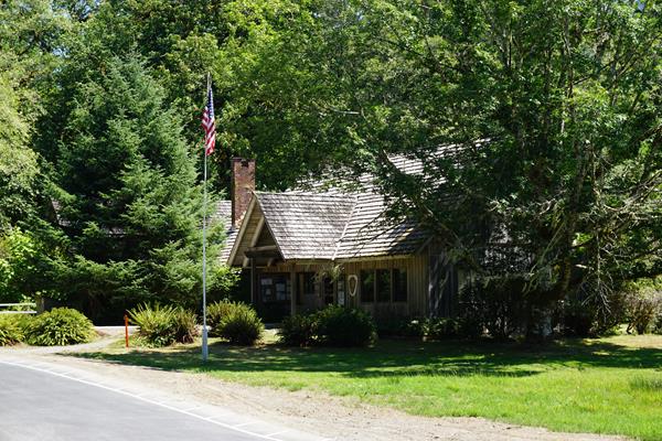 A ranger station building with a flagpole and parking lot.