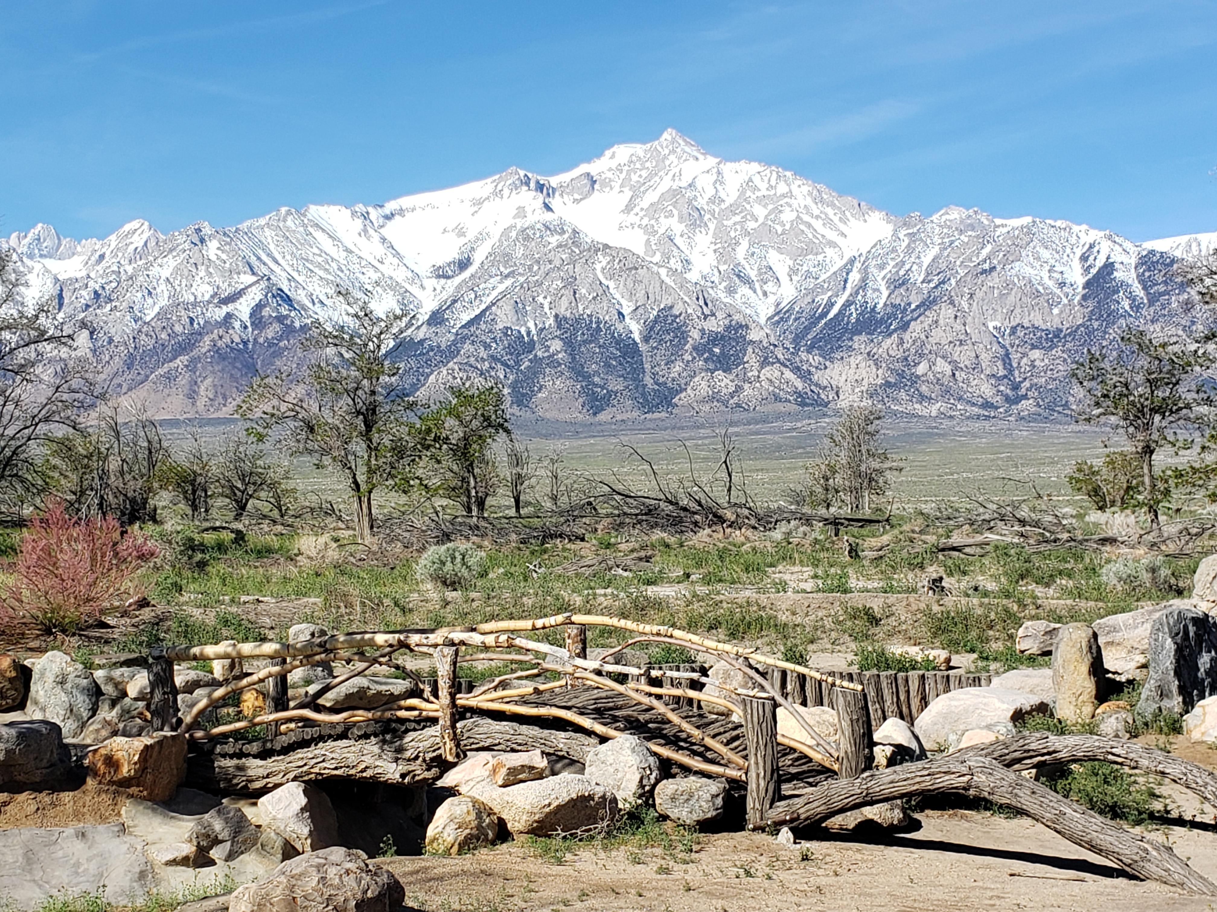 wooden bridge and stonework in foreground with mountains behind