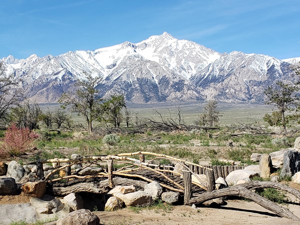 wooden bridge and stonework in foreground with mountains behind