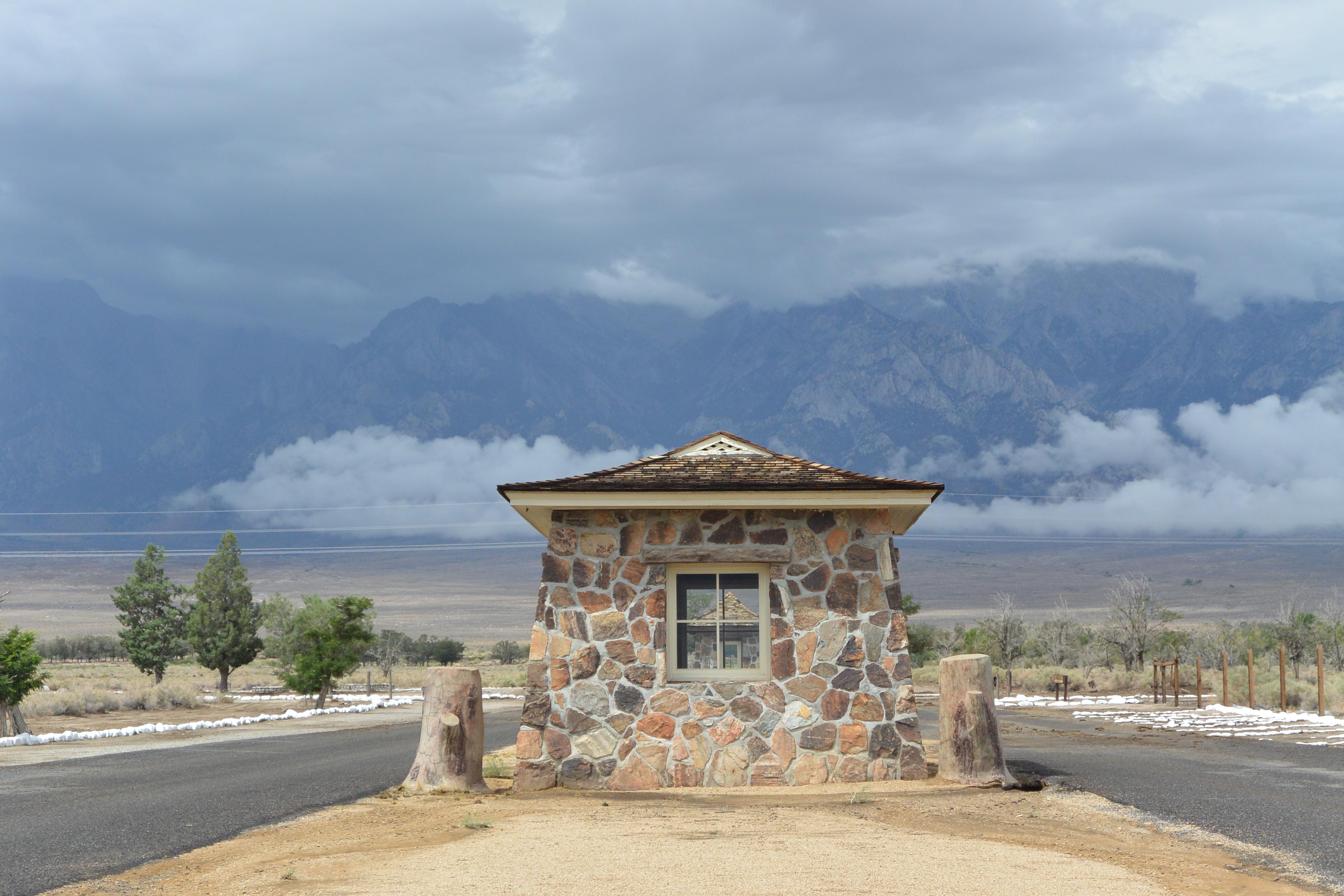stone building with stormy mountains beyond