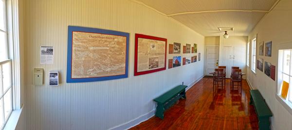 signs on walls, wood school desks and benches in small room with wood floor