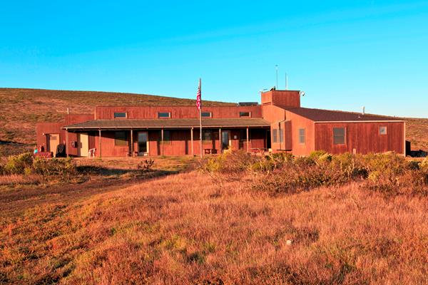 wood building with tower in dry grass