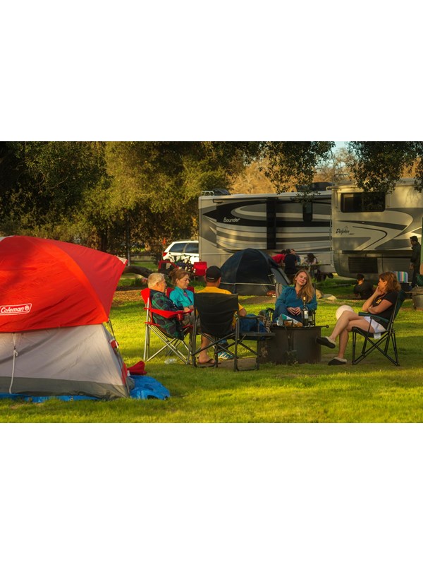 Campers gathered around a fire ring in spring