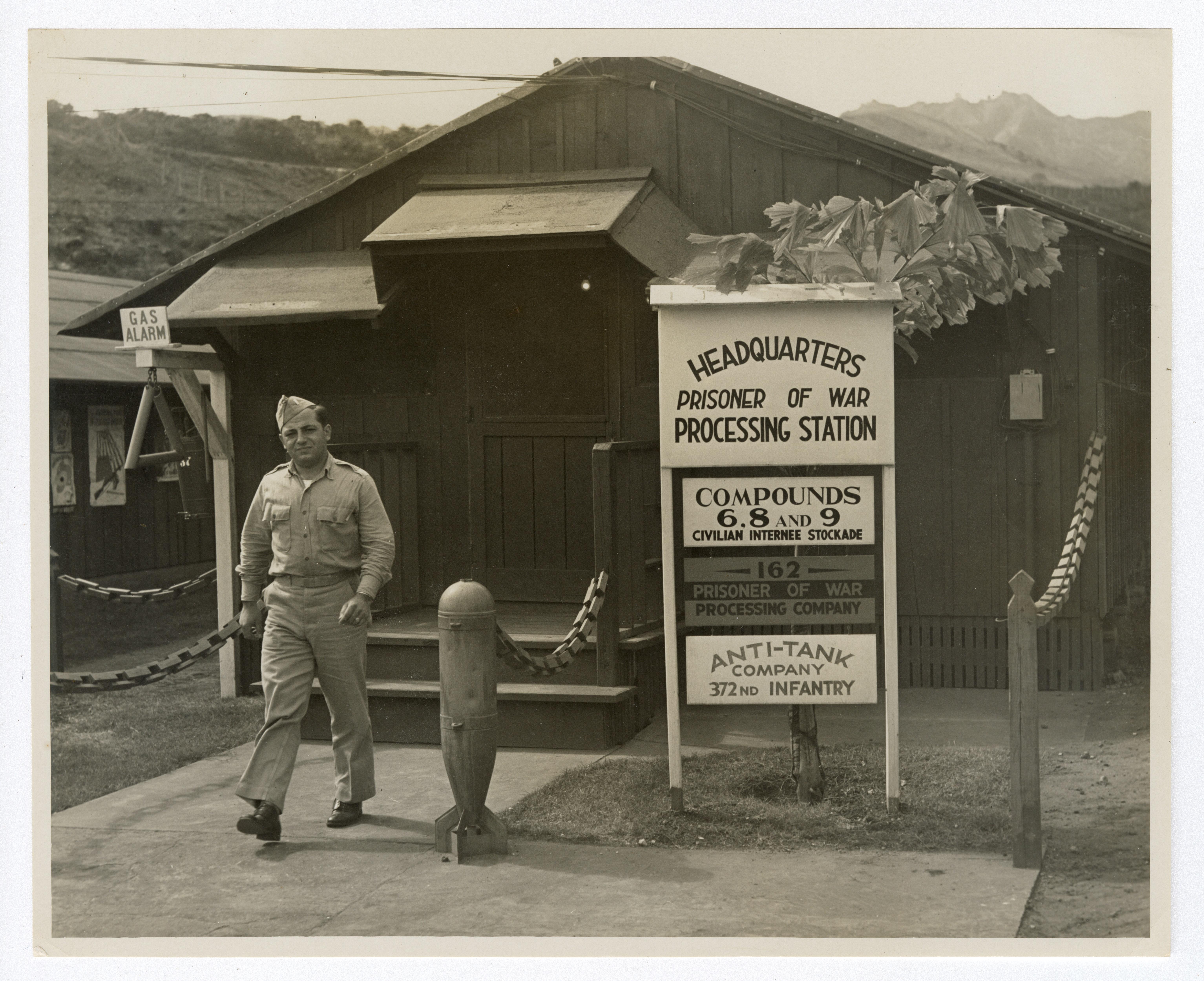 A historic photo of a soldier walking out of a barrack